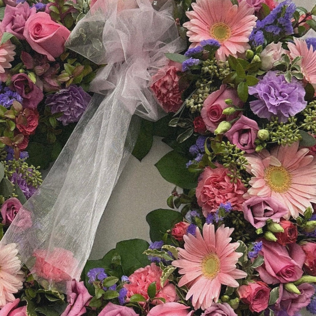 Elegant Spring Wreath with pink roses and purple blooms for sympathy, funeral arrangements, best in Toronto, same day delivery.