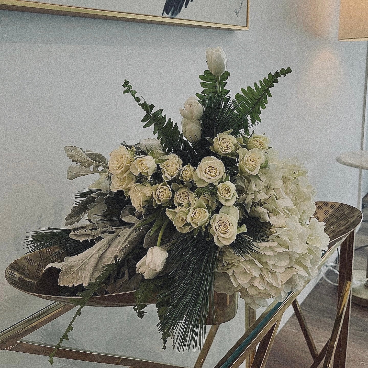 Chic and modern floral centerpiece with delicate orchids, roses, and pampas grass – perfect for sophisticated home or event decor