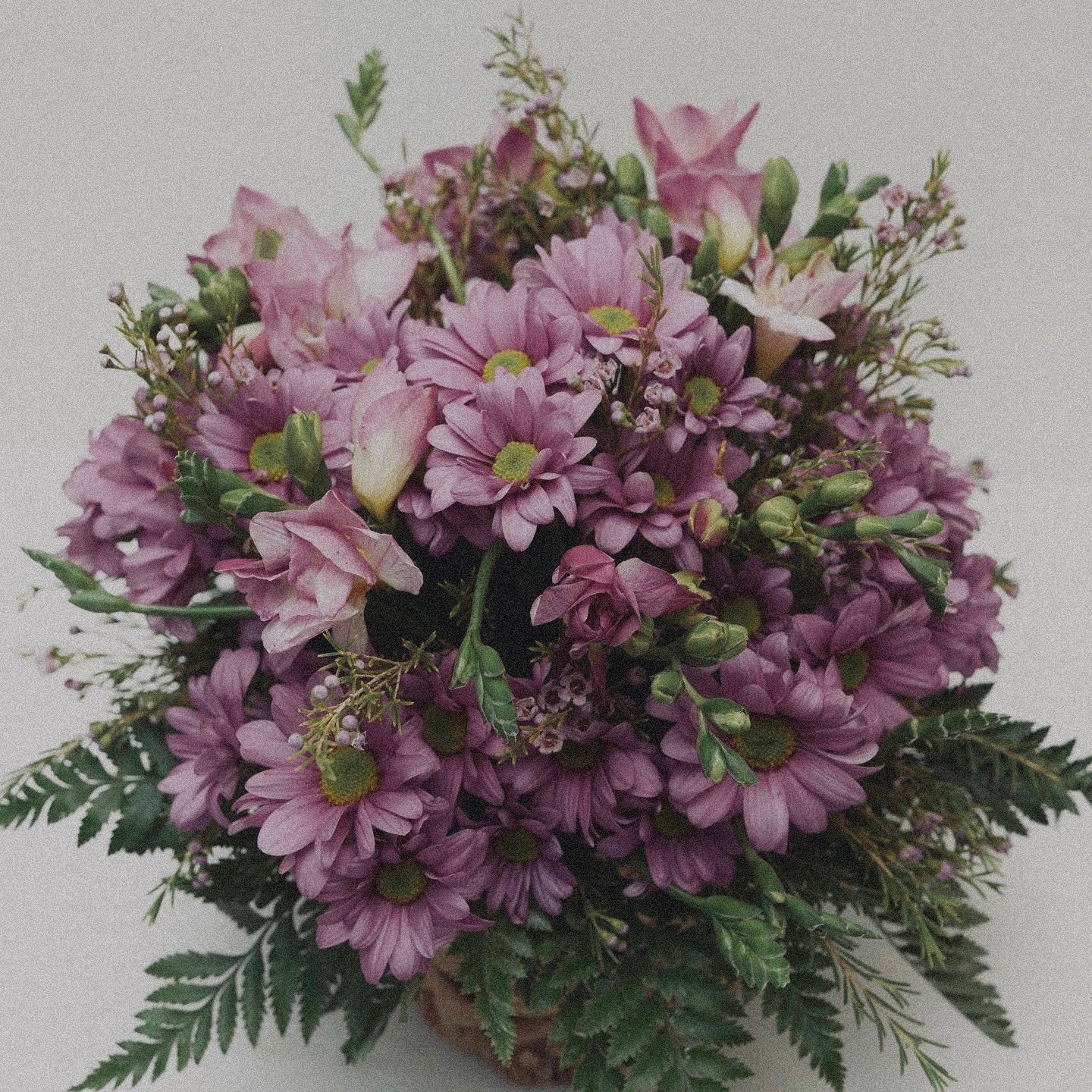 Bright and cheerful spring flower bouquet with colorful tulips, daisies, and fresh greenery.