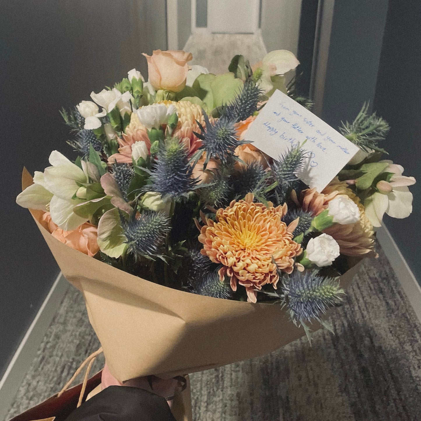 Chic and modern floral centerpiece with delicate orchids, roses, and pampas grass – perfect for sophisticated home or event decor