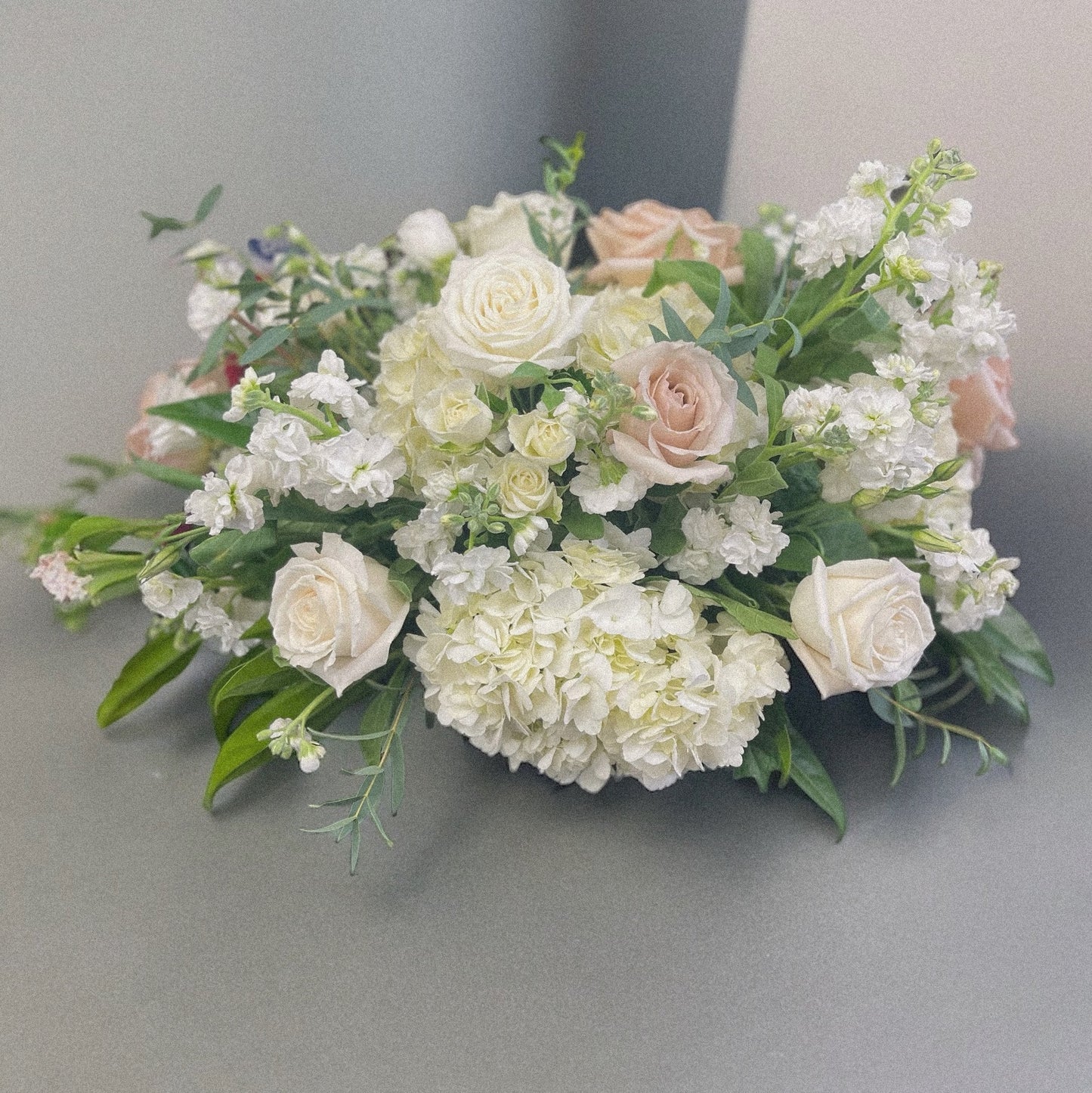 Victorian Elegance sympathy arrangement with white roses and blush tones, ideal for funeral or wreaths, available for same-day delivery in Toronto.