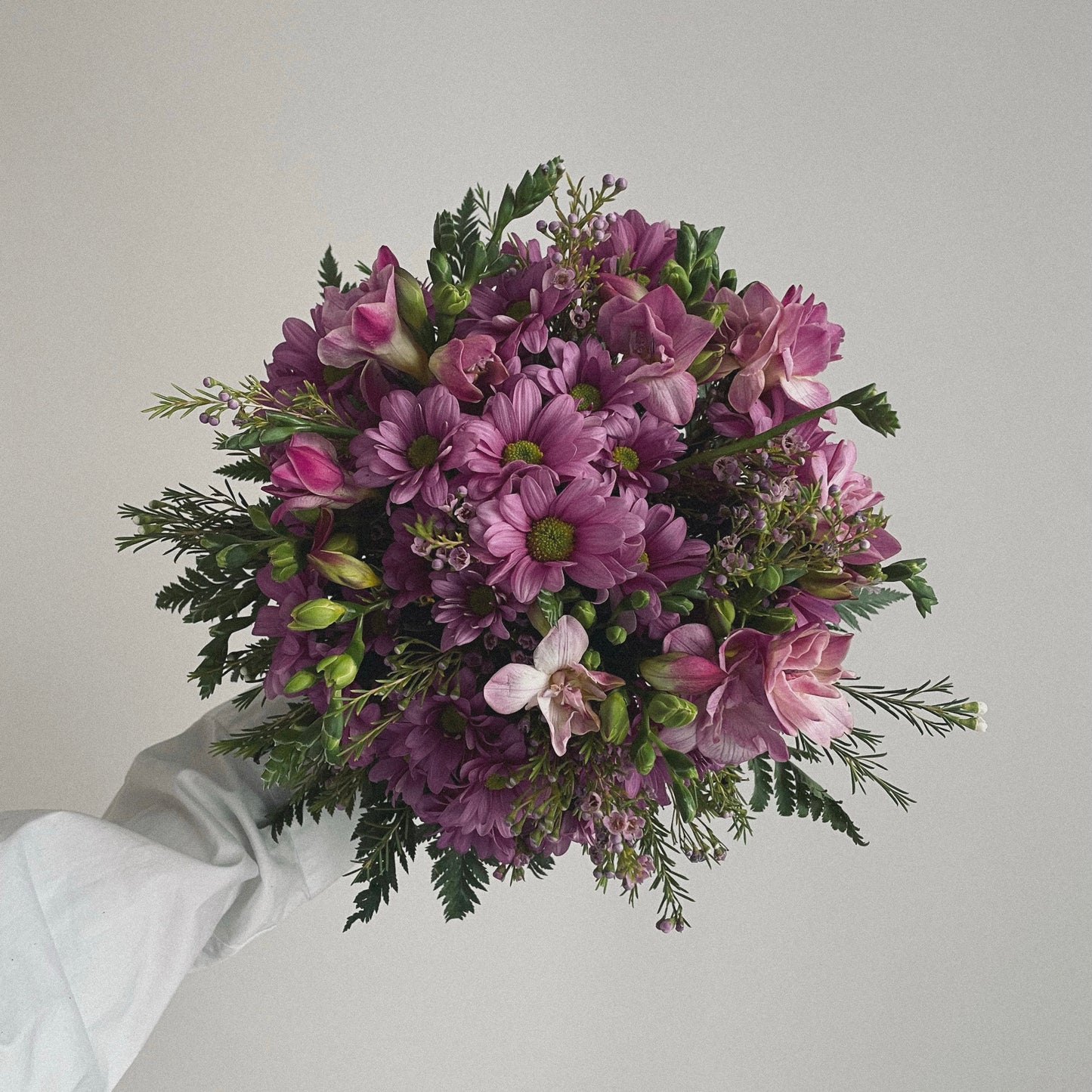 Bright and cheerful spring flower bouquet with colorful tulips, daisies, and fresh greenery.