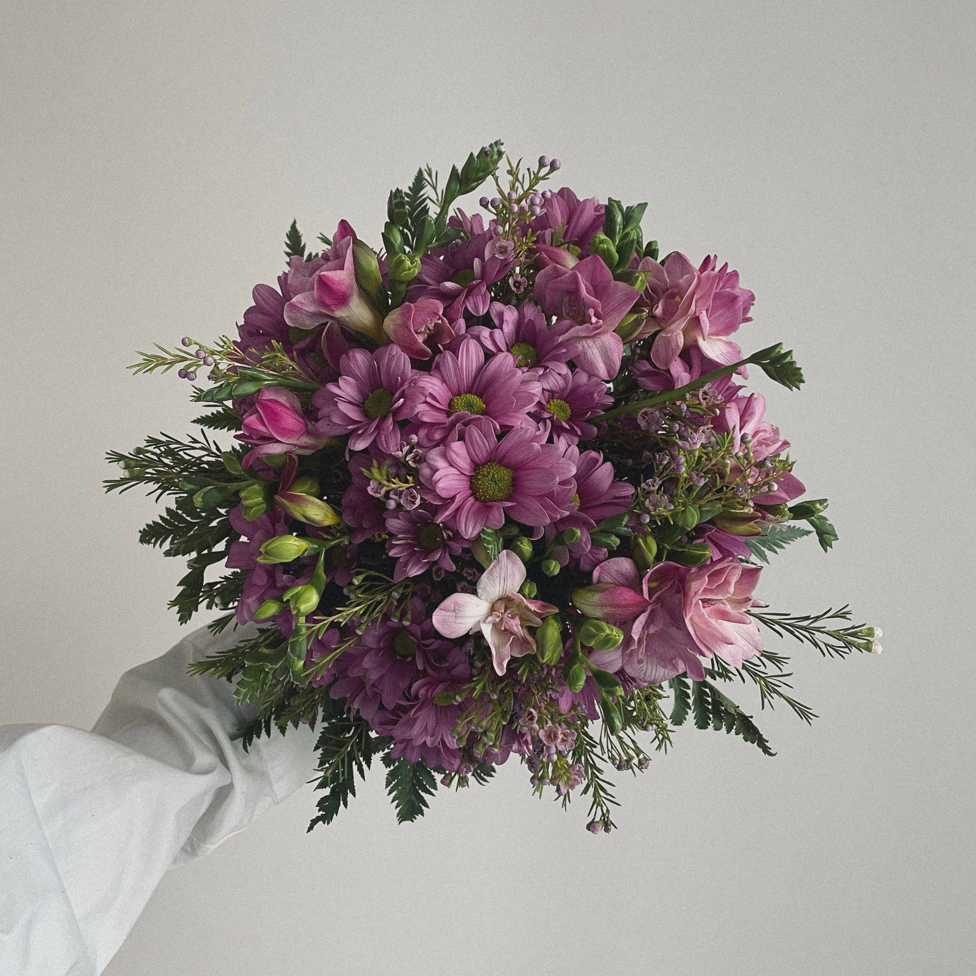 Bright and cheerful spring flower bouquet with colorful tulips, daisies, and fresh greenery.