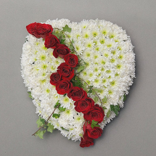 Heart-shaped funeral arrangement with white chrysanthemums and red roses, symbolizing eternal love. Luxury sympathy floral tribute, Toronto GTA.