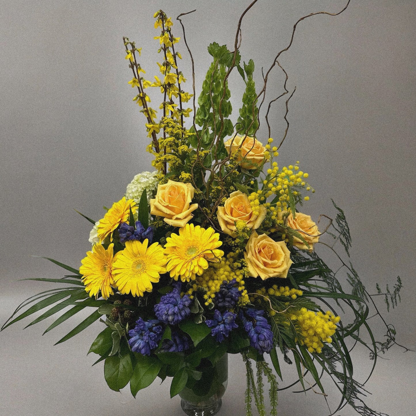 Chic and modern floral centerpiece with delicate orchids, roses, and pampas grass – perfect for sophisticated home or event decor