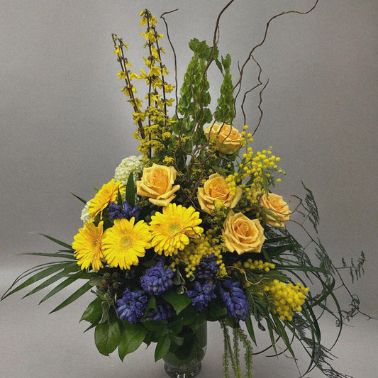 Chic and modern floral centerpiece with delicate orchids, roses, and pampas grass – perfect for sophisticated home or event decor