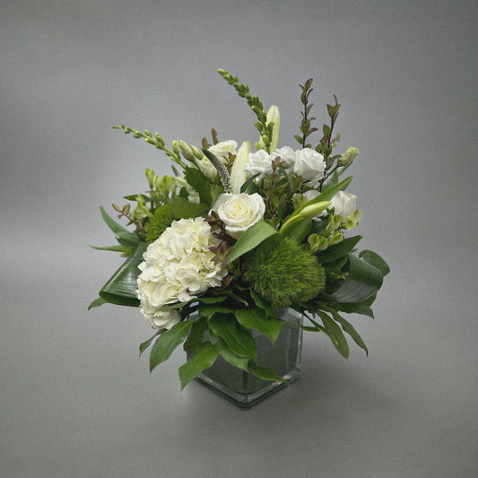 Luxury white floral arrangement with hydrangeas, roses, and lilies in a glass vase. Perfect for any occasion, best florist in Toronto.