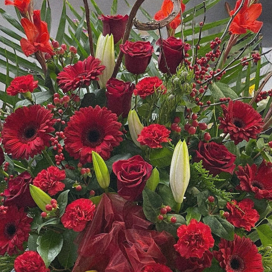 Luxury red funeral arrangement with roses, gerberas, and lilies. Best in Toronto for sympathy, same-day delivery available.
