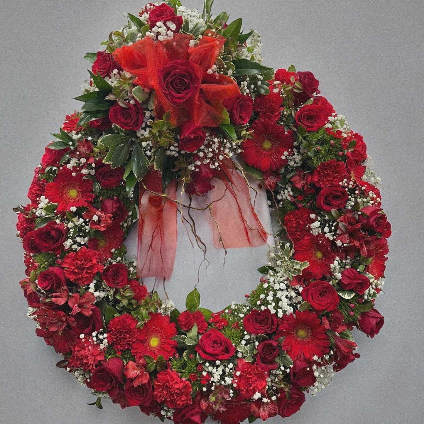 Crimson Tribute sympathy funeral arrangement with red roses and blooms, luxury wreath, Toronto GTA, same day delivery available.