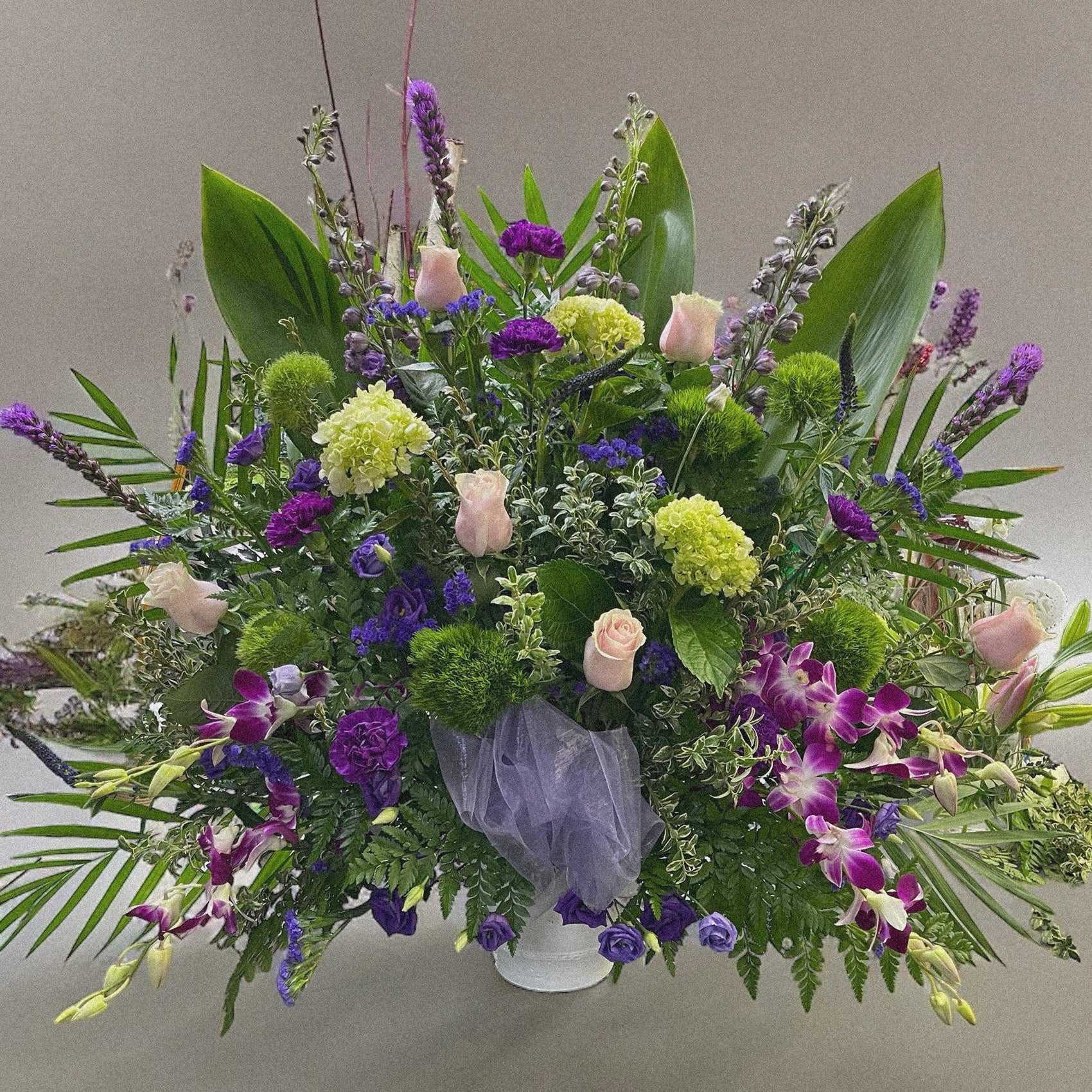 Lavender Garden Arrangement - A serene funeral tribute with soft pink roses and rich purples. Best sympathy wreaths in Toronto, same-day delivery.