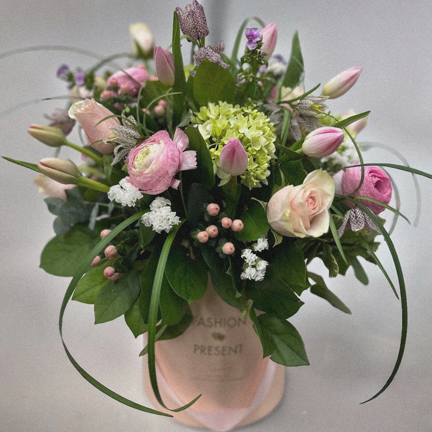 Pastel Harmony bouquet with pink roses, ranunculus, tulips, hydrangeas in a pink hatbox by best florist in Toronto; luxury flowers