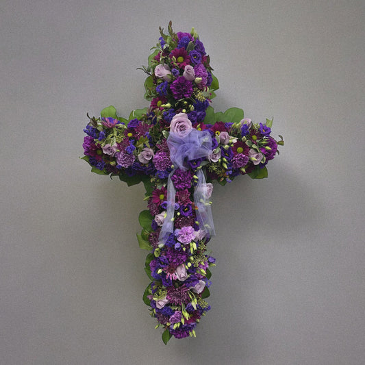 Elegant Purple Cross funeral floral arrangement with lavender flowers, symbolizing peace and spirituality. Best sympathy wreath, Toronto delivery.