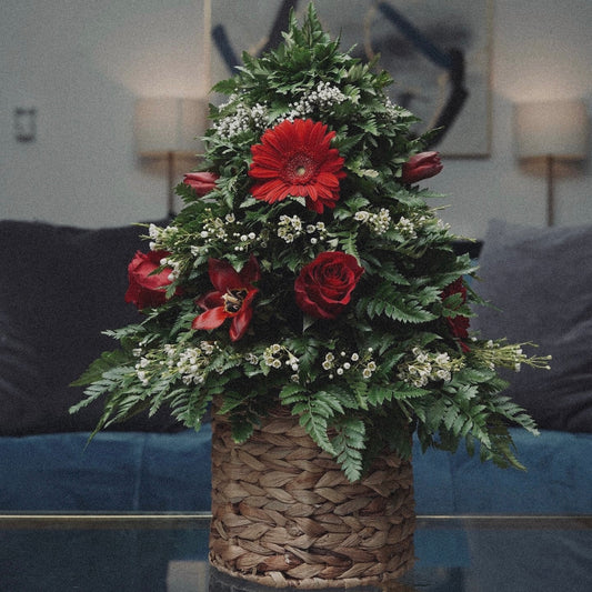 Winter-themed floral centerpiece with white roses, pinecones, and festive greenery, perfect for holiday decor.