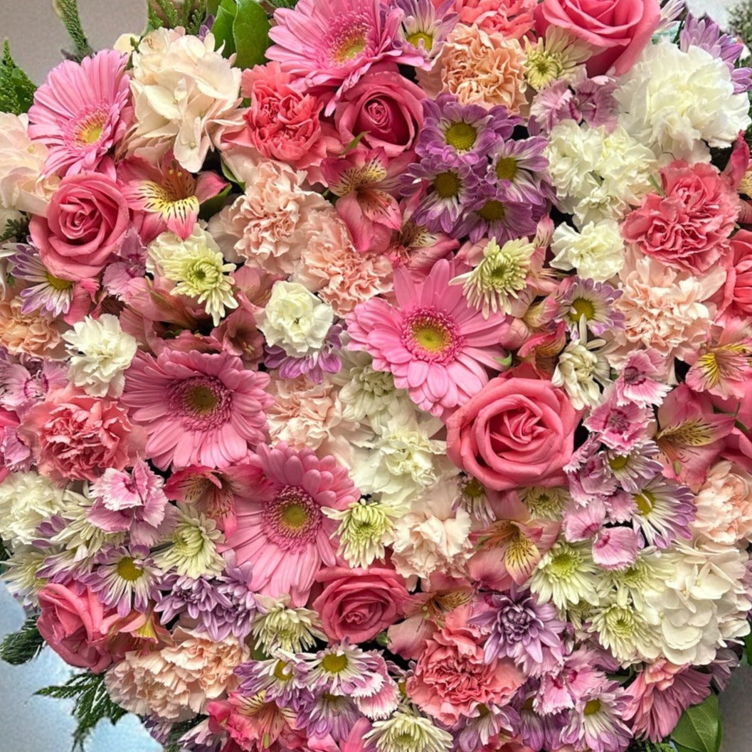 Heart-shaped wreath with soft pink and white blooms, perfect for sympathy or funeral arrangements, best luxury flowers in Toronto, same day delivery.