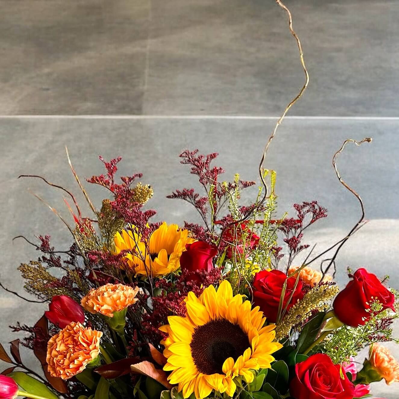Golden Radiance Bouquet – Sunflower & Rose Fall Arrangement with vibrant sunflowers, red roses, and orange carnations.