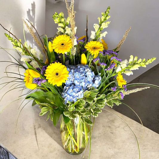 Autumn-inspired bouquet with warm-toned chrysanthemums, sunflowers, and seasonal foliage.