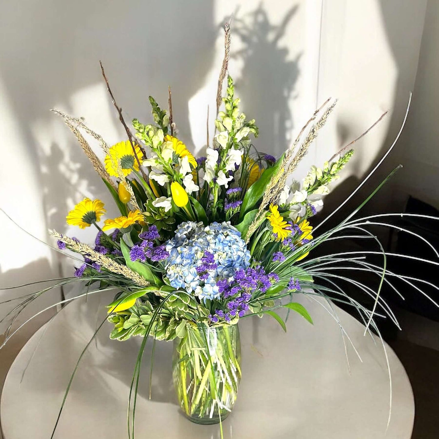 Autumn-inspired bouquet with warm-toned chrysanthemums, sunflowers, and seasonal foliage.
