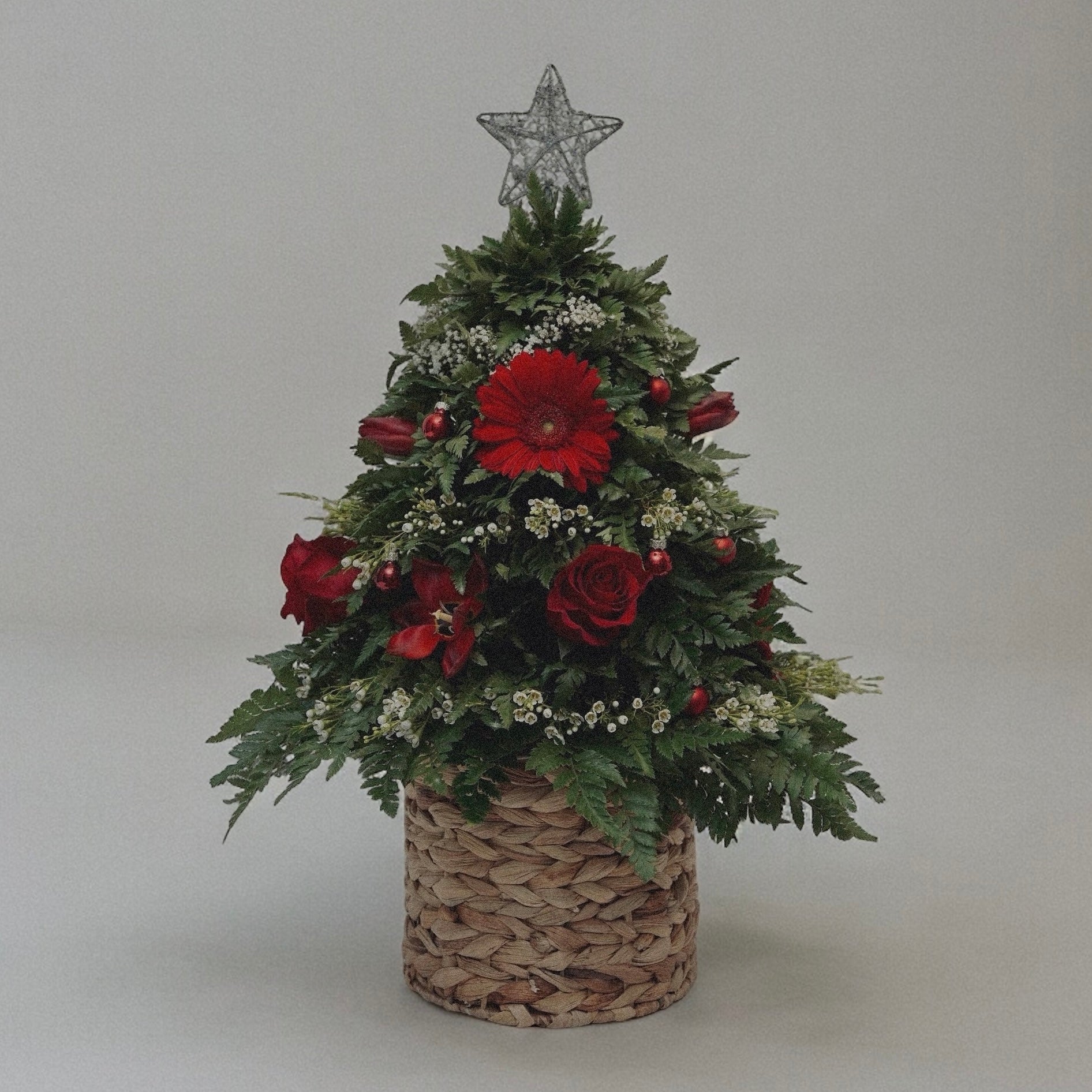 Winter-themed floral centerpiece with white roses, pinecones, and festive greenery, perfect for holiday decor.