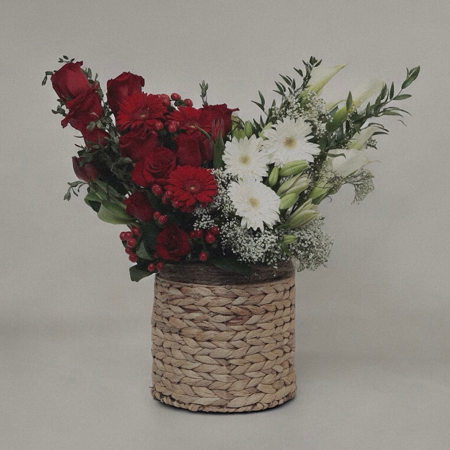 Winter-themed floral centerpiece with white roses, pinecones, and festive greenery, perfect for holiday decor.