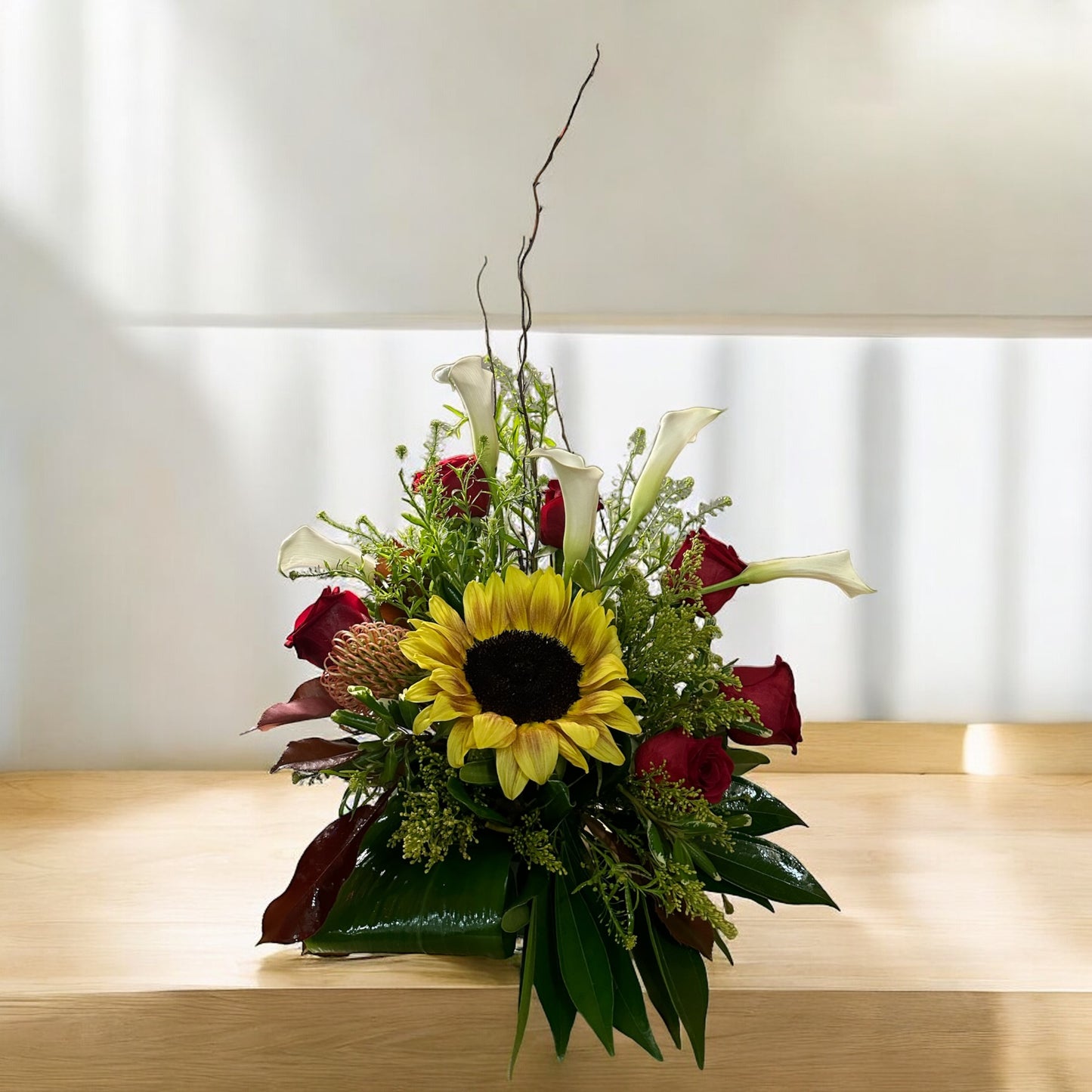 Sunlit Romance floral arrangement with sunflowers, red roses, white calla lilies, and greenery, best Toronto florist, same day delivery.