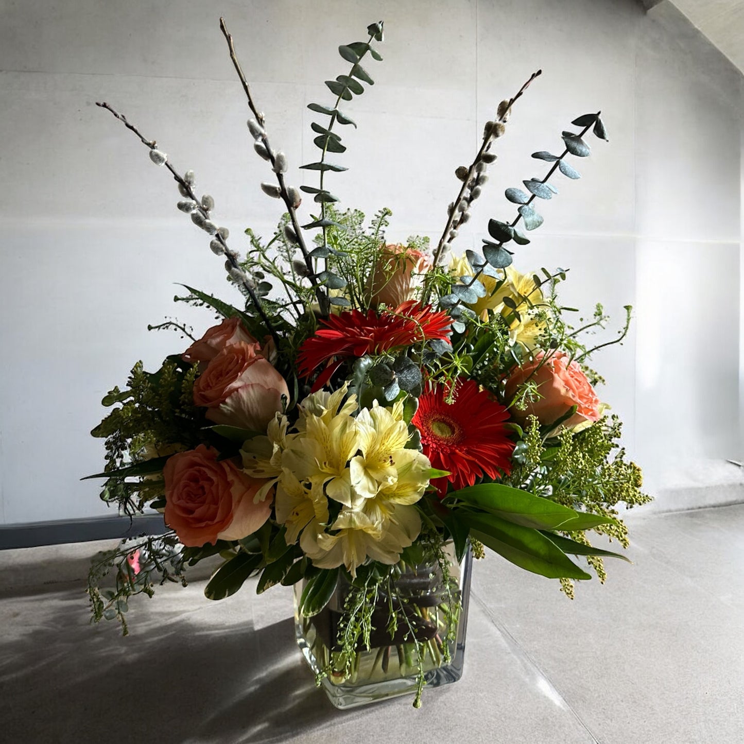 Celestial Serenade floral arrangement in a square glass vase, showcasing roses, gerberas, and lush greens. Toronto's best flowers shop, luxury flowers.
