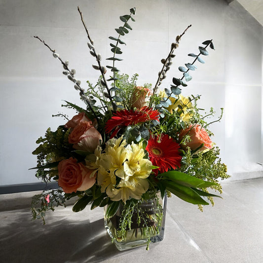 Celestial Serenade floral arrangement in a square glass vase, showcasing roses, gerberas, and lush greens. Toronto's best flowers shop, luxury flowers.