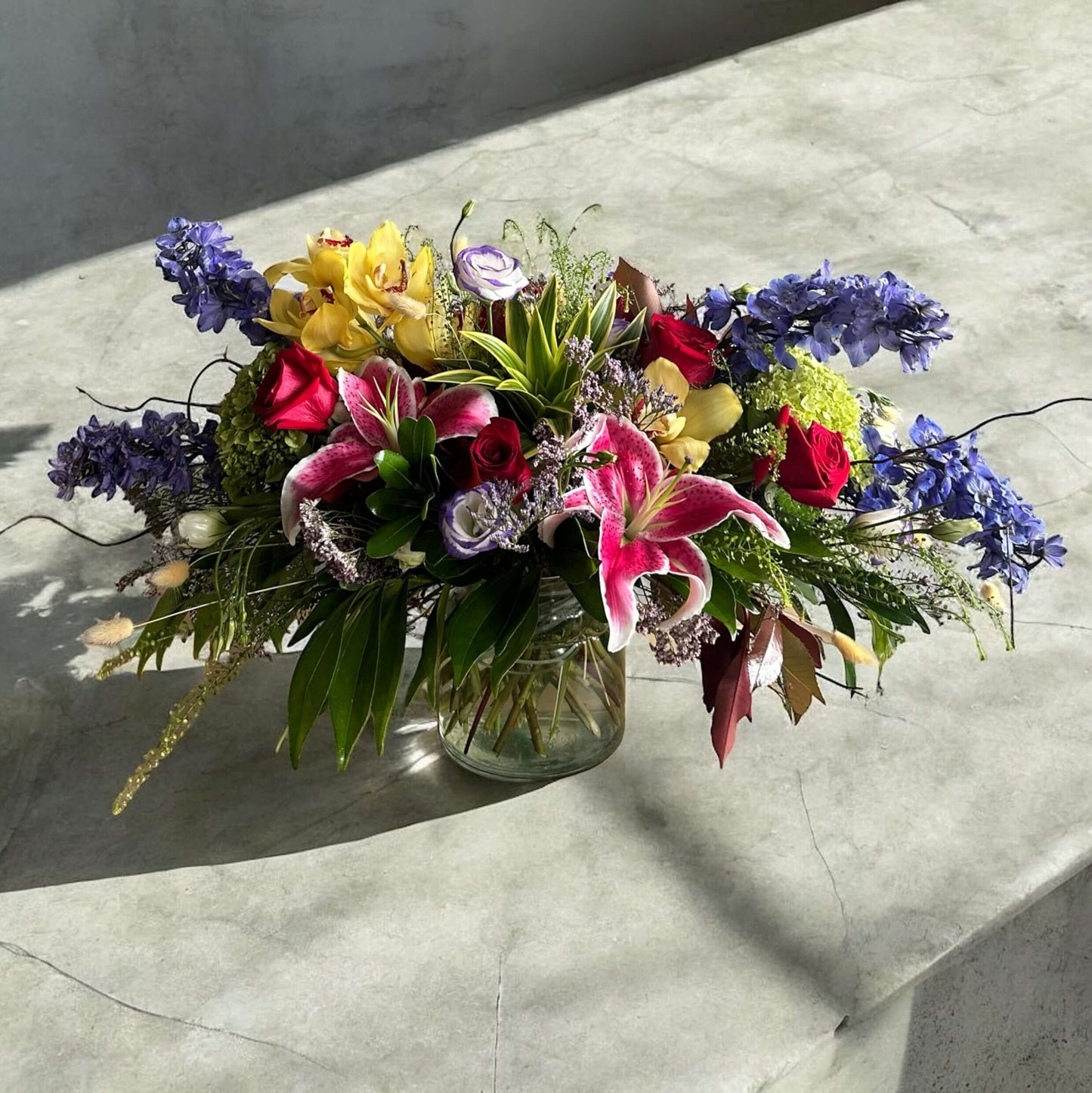 Enchanted Garden Bouquet featuring roses, lilies, orchids and delphiniums in a luxury arrangement for same day delivery in Toronto.