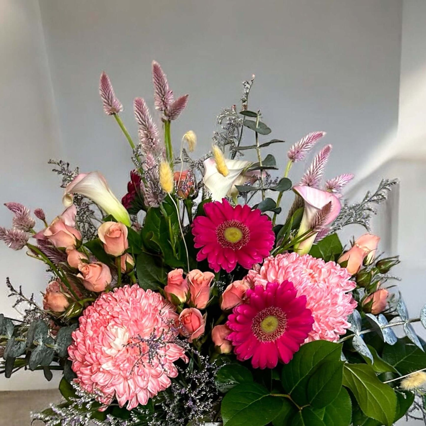 Vibrant mixed flower bouquet with bright gerbera daisies, roses, and fresh greenery, beautifully arranged for any special occasion.