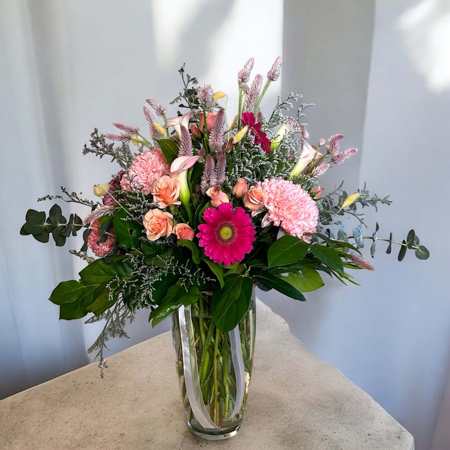 Vibrant mixed flower bouquet with bright gerbera daisies, roses, and fresh greenery, beautifully arranged for any special occasion.