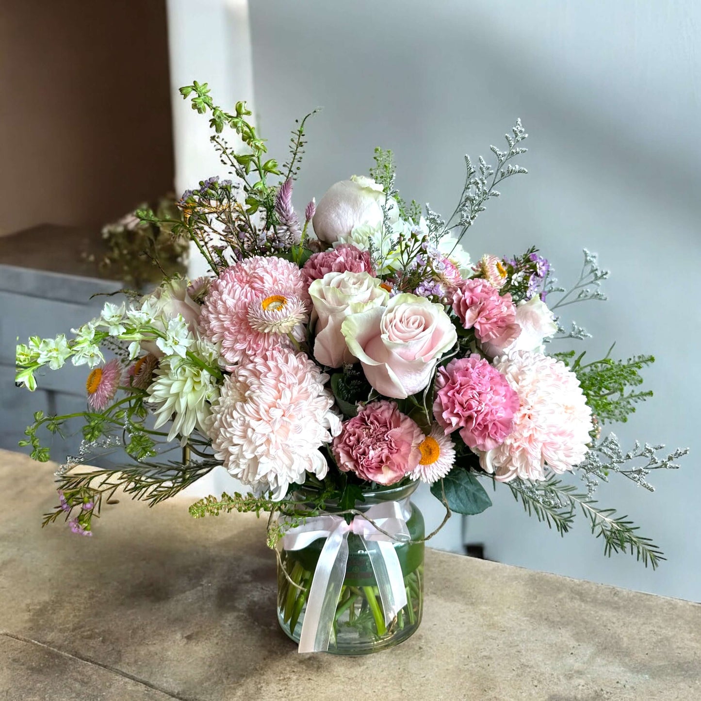 Bright and cheerful spring flower bouquet with colorful tulips, daisies, and fresh greenery.