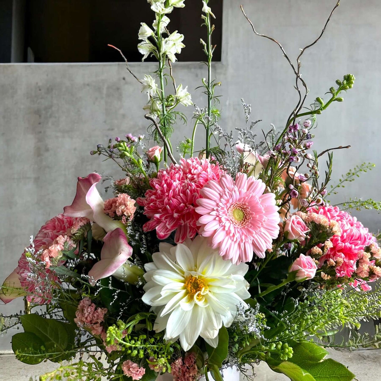 Bright and cheerful spring flower bouquet with colorful tulips, daisies, and fresh greenery.