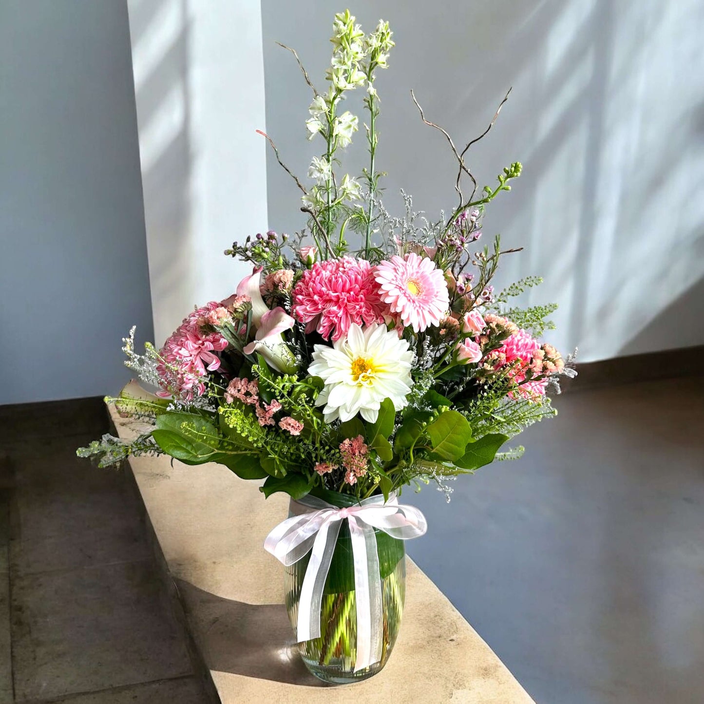 Bright and cheerful spring flower bouquet with colorful tulips, daisies, and fresh greenery.