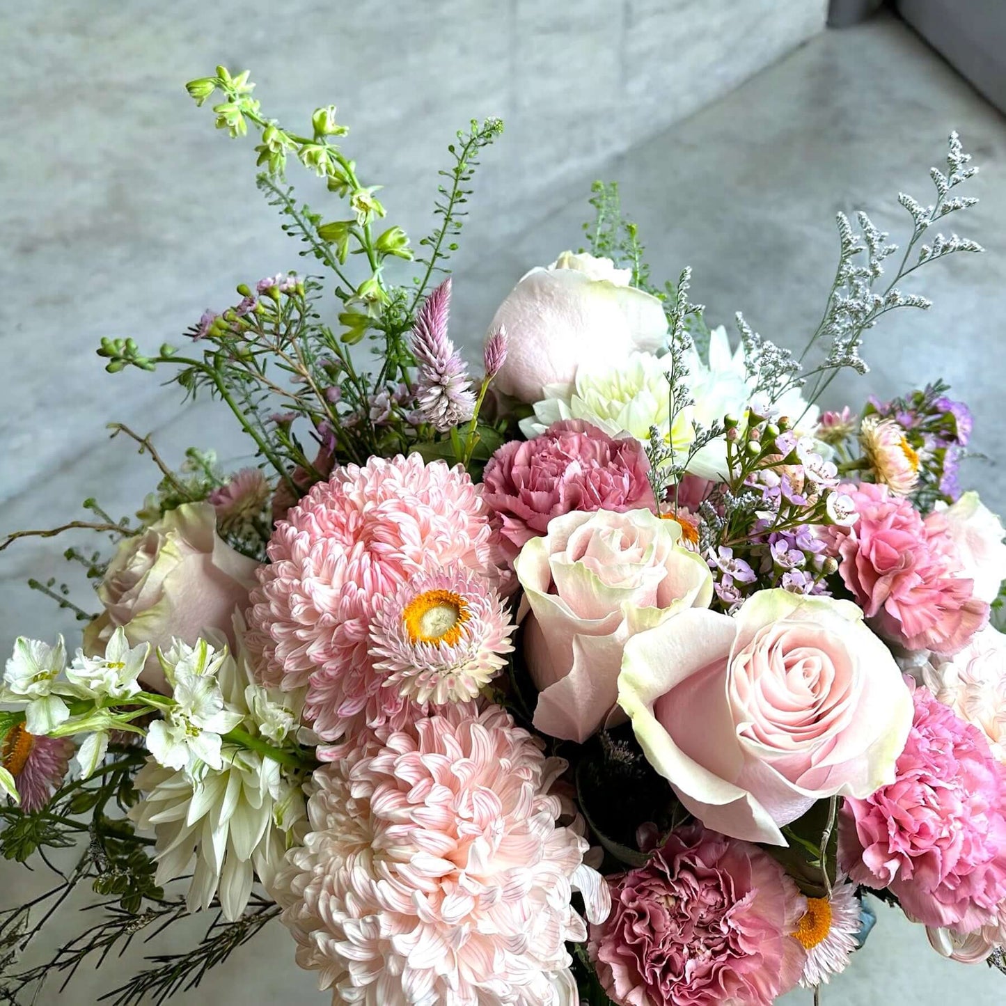 Bright and cheerful spring flower bouquet with colorful tulips, daisies, and fresh greenery.
