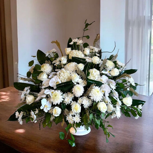 Elegant white sympathy flowers in a luxurious arrangement for tributes and condolences.