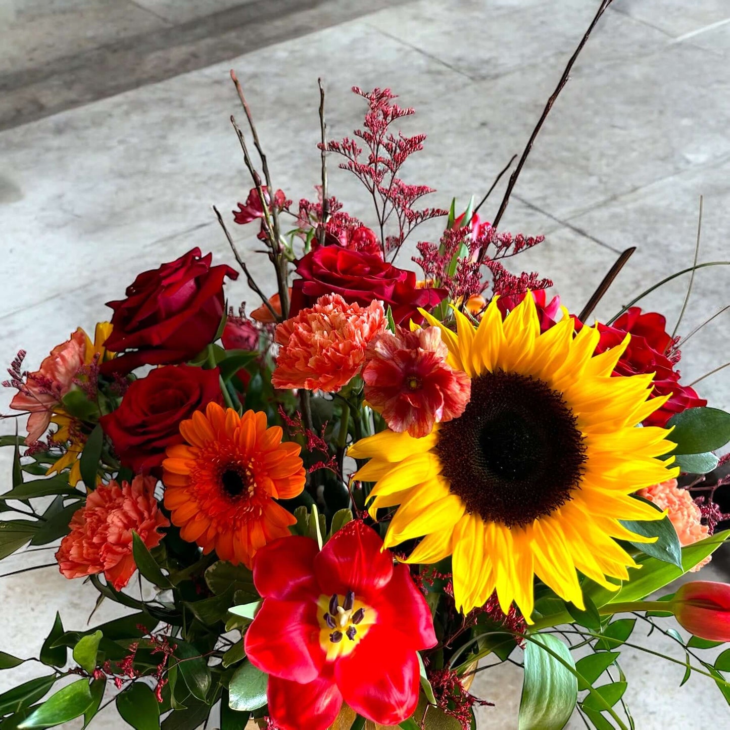 Autumn-inspired bouquet with warm-toned chrysanthemums, sunflowers, and seasonal foliage.