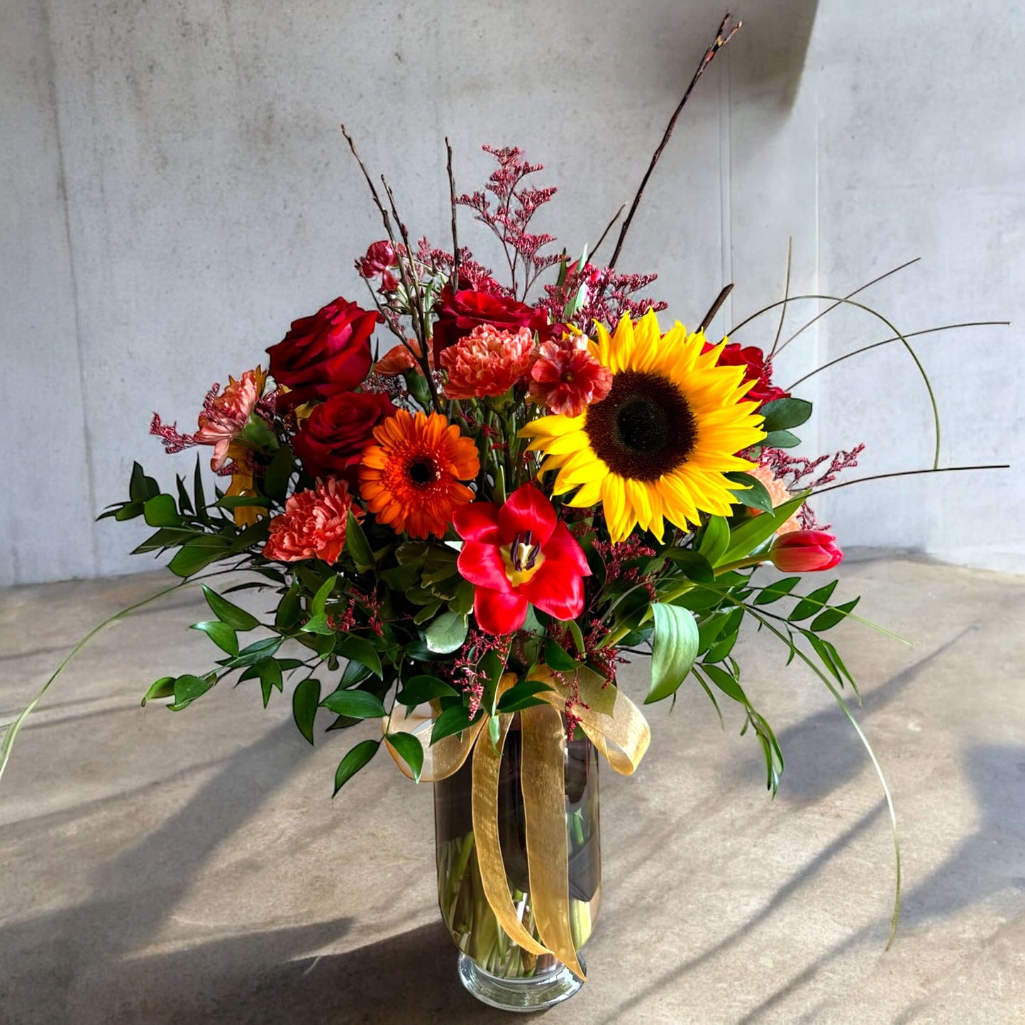 Autumn-inspired bouquet with warm-toned chrysanthemums, sunflowers, and seasonal foliage.