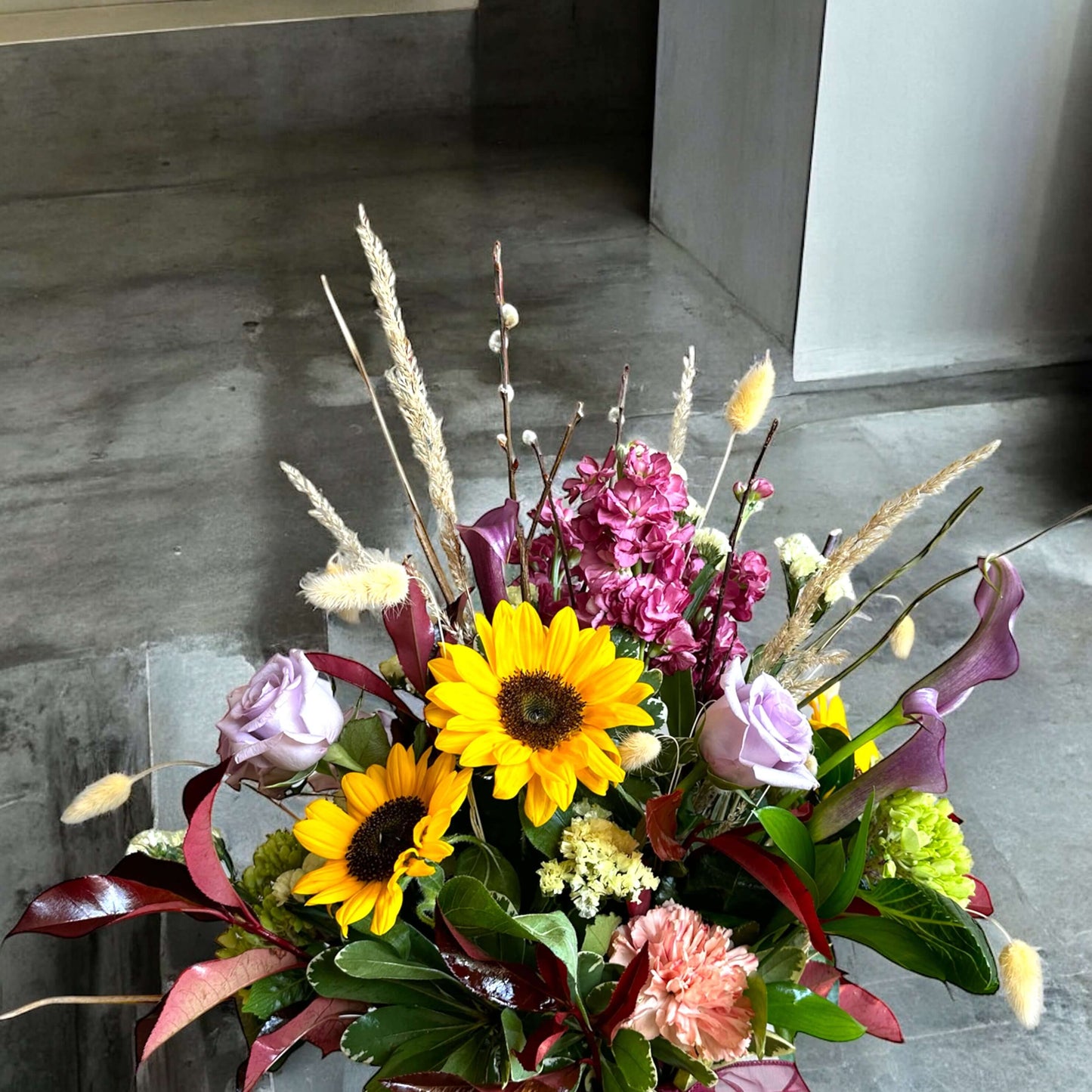 Chic and modern floral centerpiece with delicate orchids, roses, and pampas grass – perfect for sophisticated home or event decor