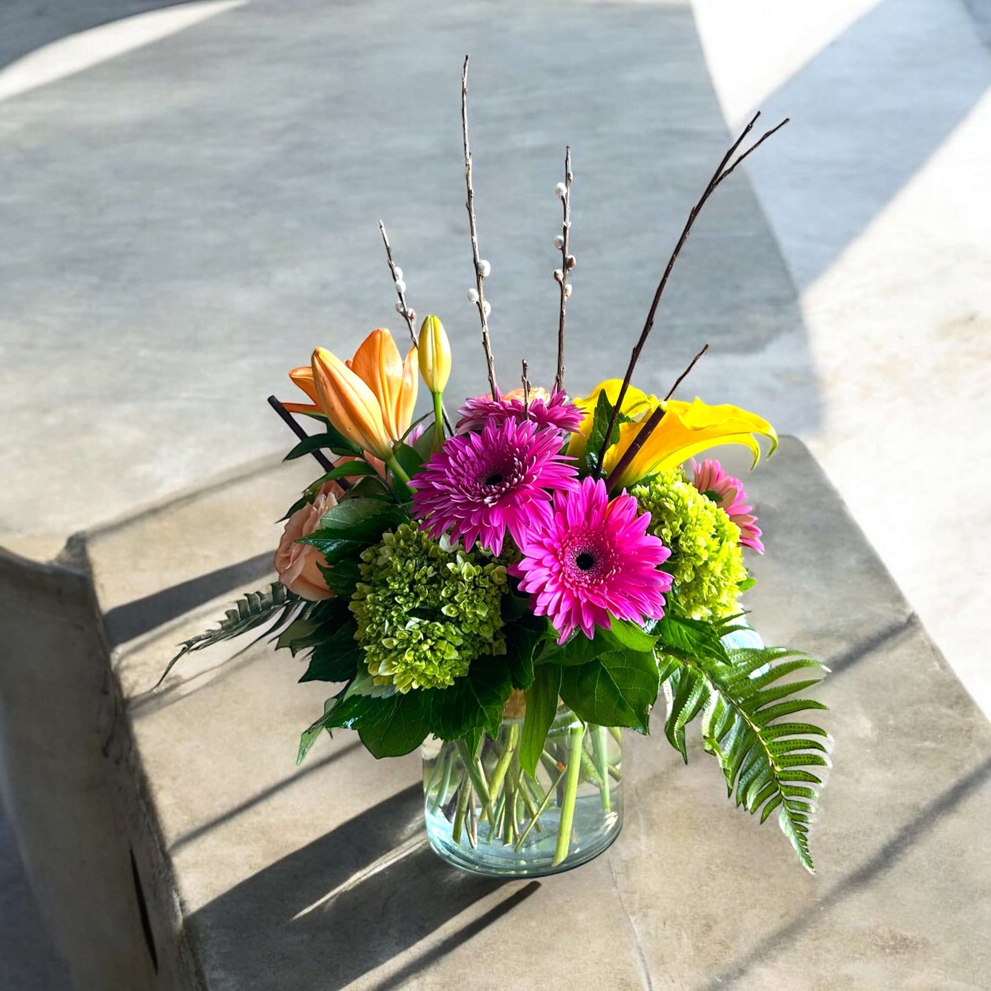 Bright and cheerful spring flower bouquet with colorful tulips, daisies, and fresh greenery.