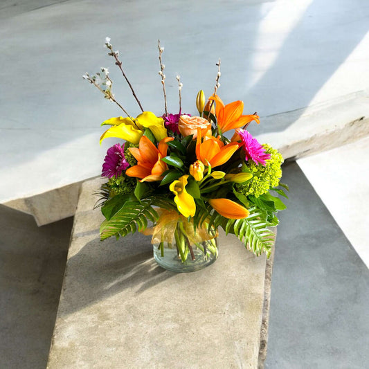Bright and cheerful spring flower bouquet with colorful tulips, daisies, and fresh greenery.