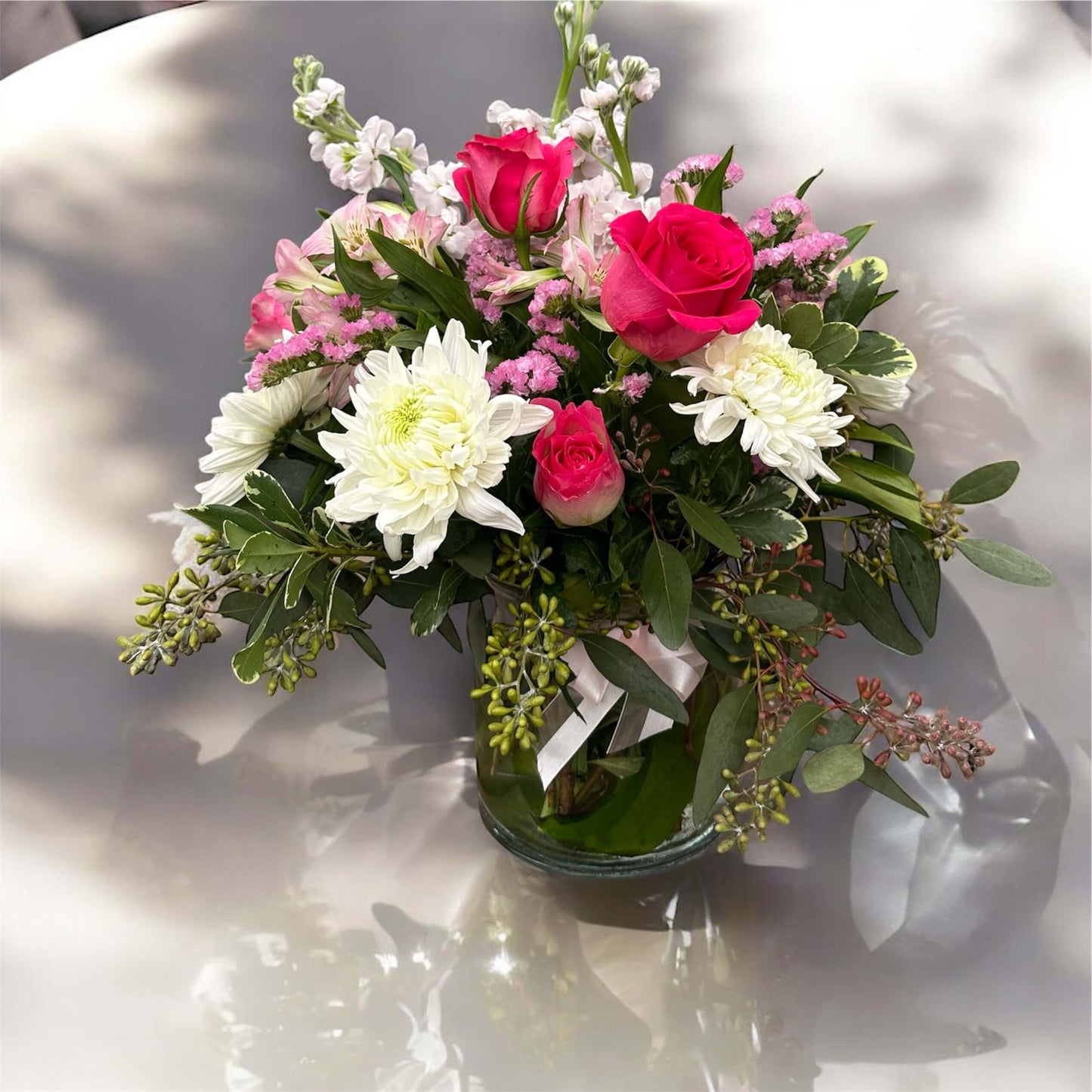 Chic and modern floral centerpiece with delicate orchids, roses, and pampas grass – perfect for sophisticated home or event decor.