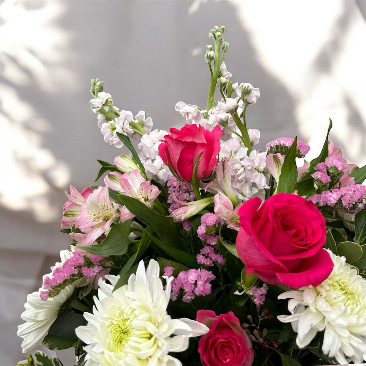 Chic and modern floral centerpiece with delicate orchids, roses, and pampas grass – perfect for sophisticated home or event decor.