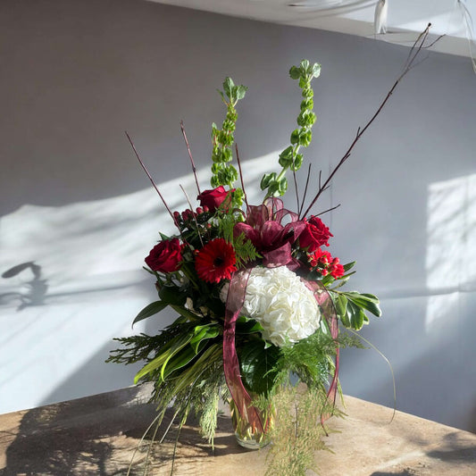 Love-inspired flower arrangement with red tulips, roses, and heart-shaped accents, the ultimate gift for anniversaries