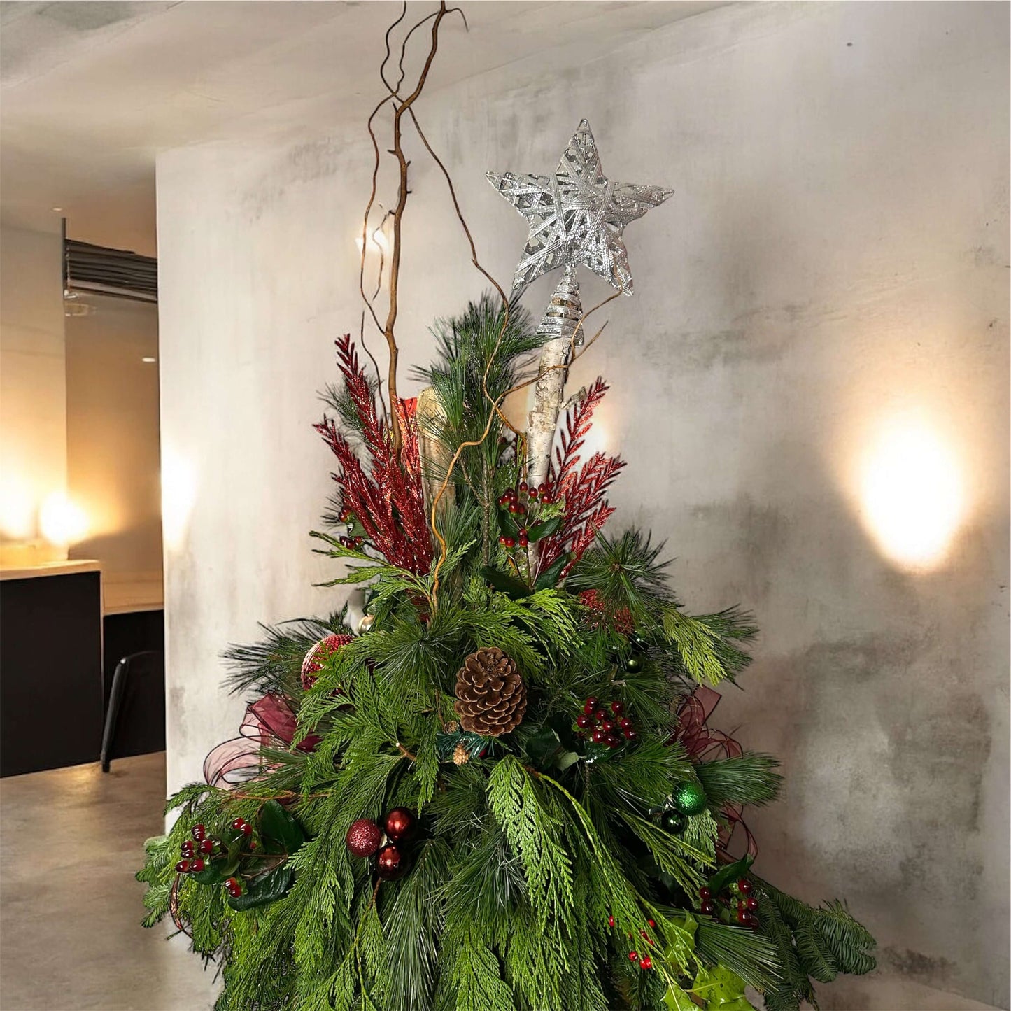 Winter-themed floral centerpiece with white roses, pinecones, and festive greenery, perfect for holiday decor.