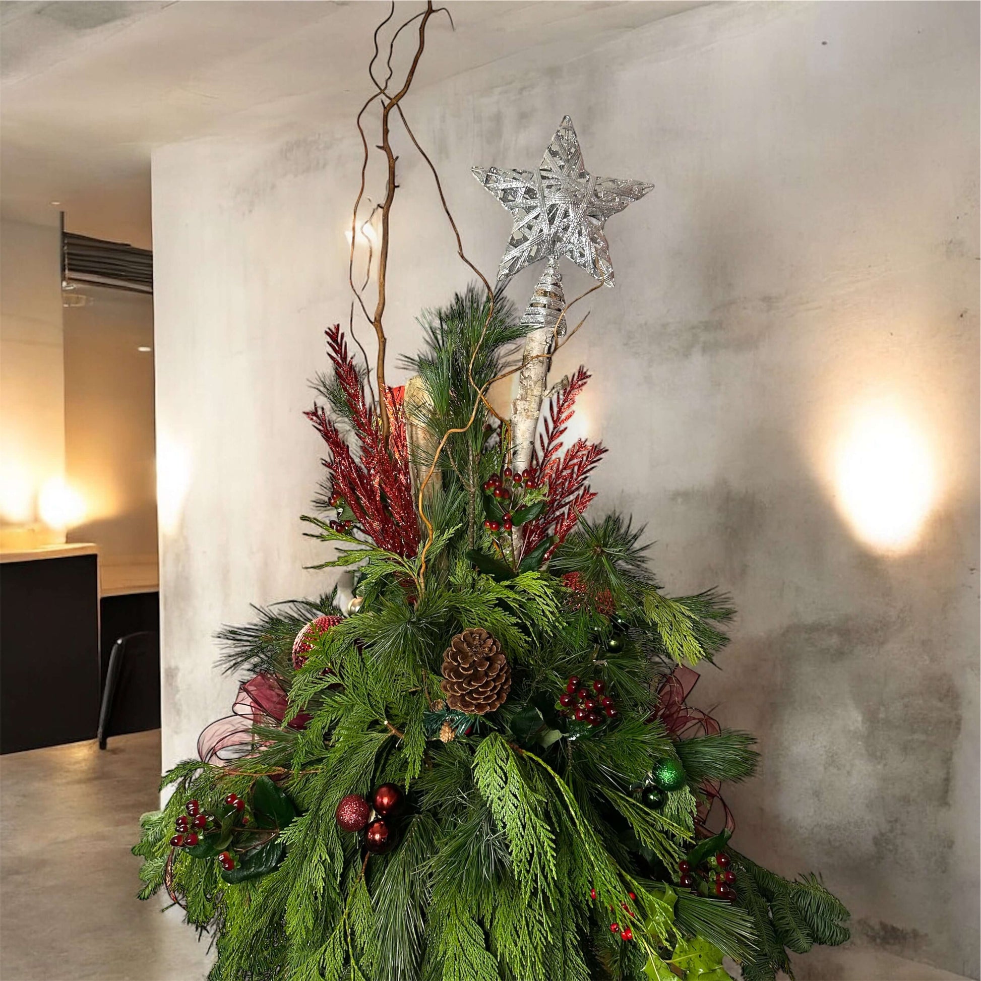 Winter-themed floral centerpiece with white roses, pinecones, and festive greenery, perfect for holiday decor.
