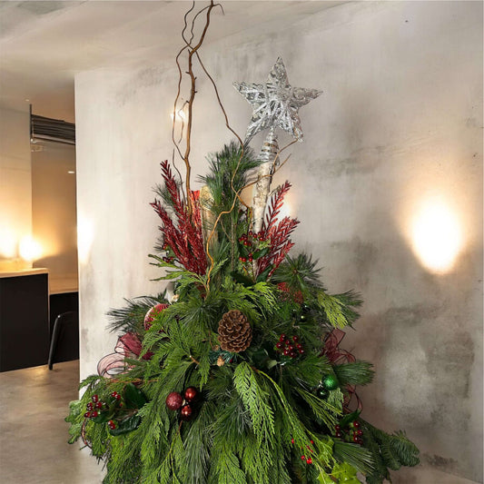 Winter-themed floral centerpiece with white roses, pinecones, and festive greenery, perfect for holiday decor.