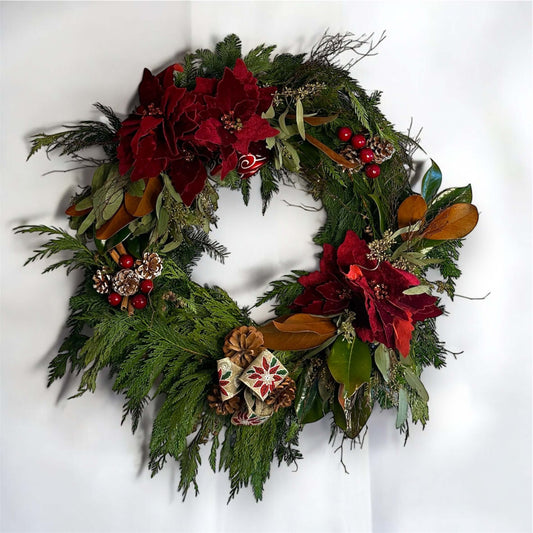 Winter-themed floral wreath with white roses, pinecones, and festive greenery, perfect for holiday decor.
