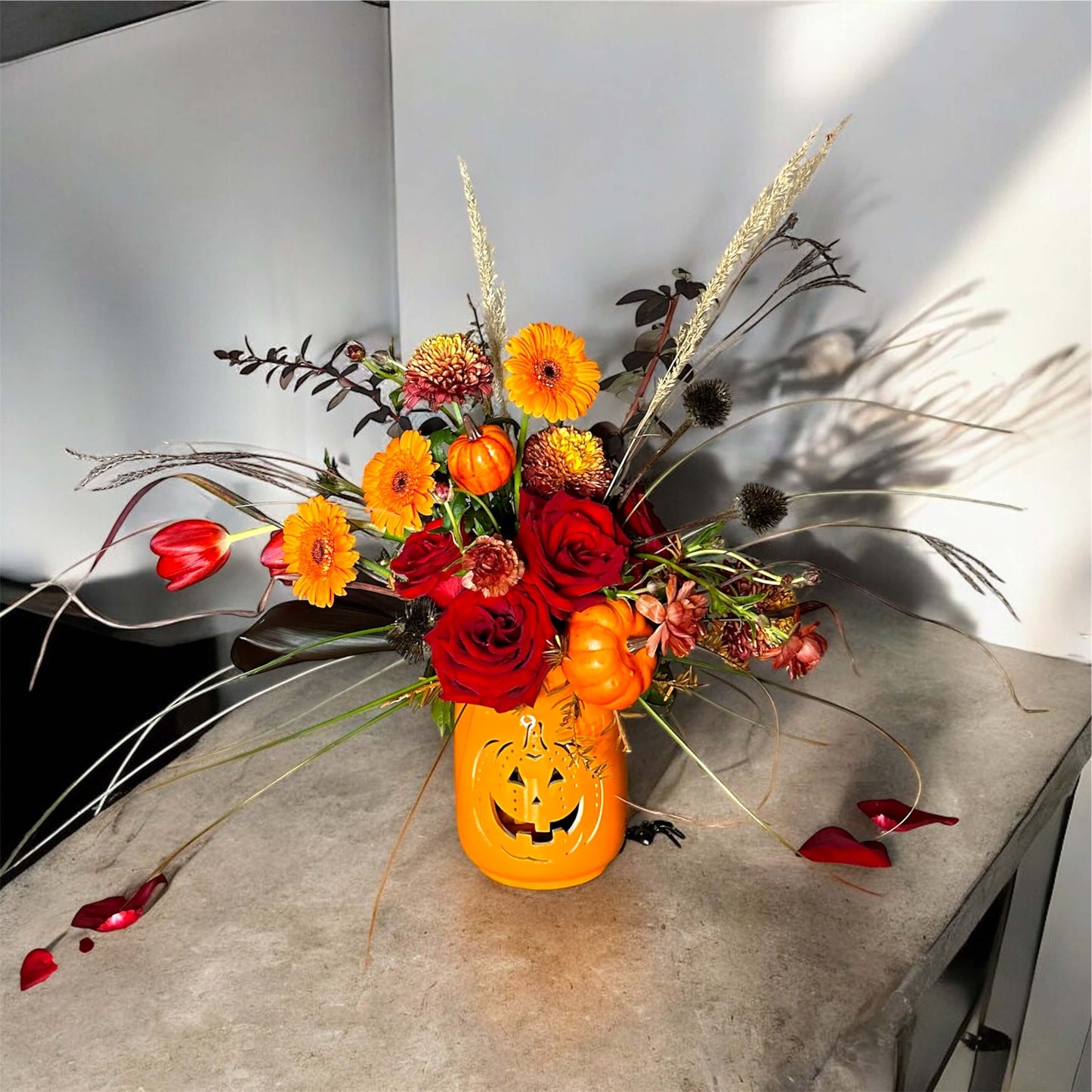 Chic and modern floral centerpiece with delicate orchids, roses, and pampas grass – perfect for sophisticated home or event decor."