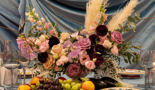 "Chic and modern floral centerpiece with delicate orchids, roses, and pampas grass – perfect for sophisticated home or event decor