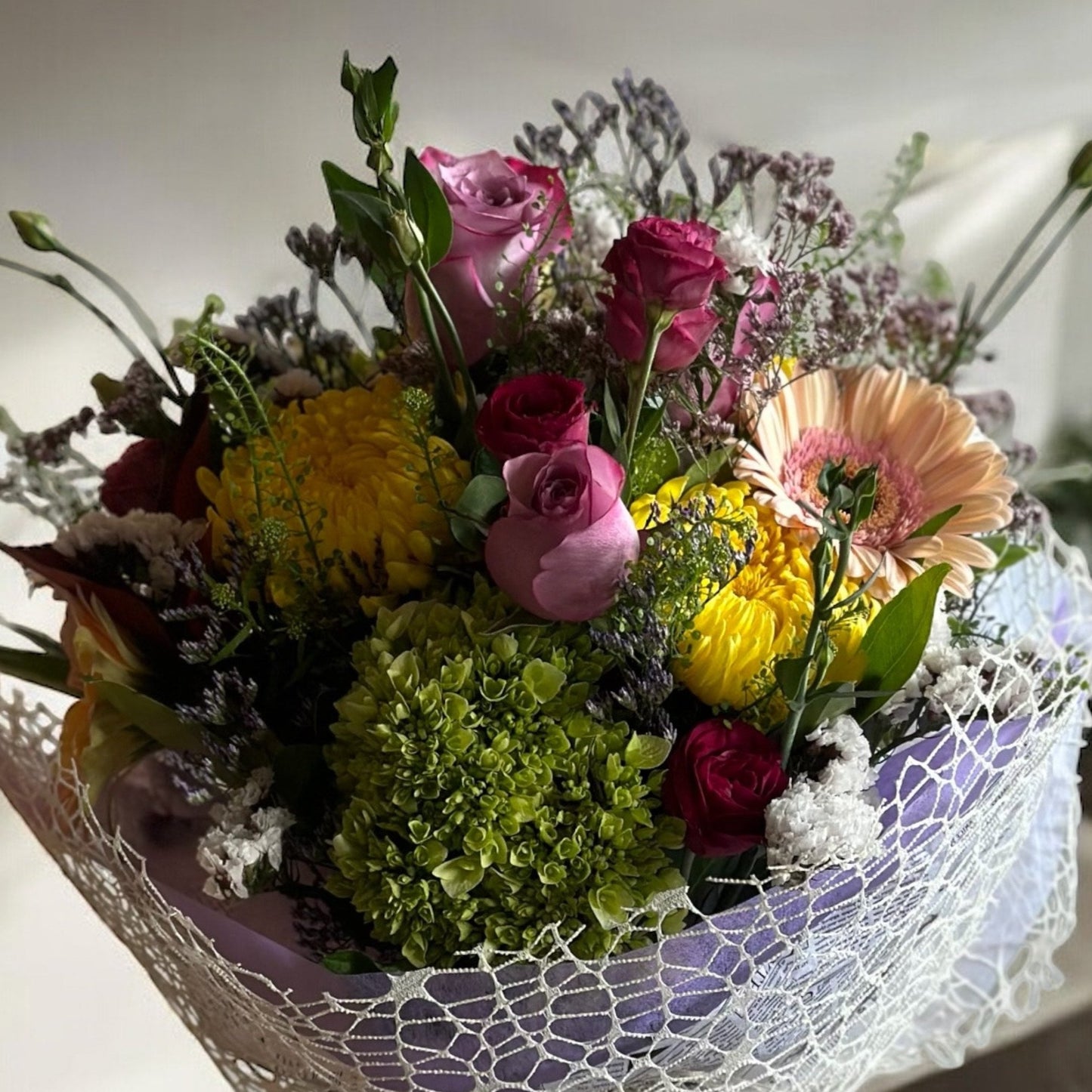 Pastel-colored spring bouquet featuring soft pink peonies, roses, and delicate filler flowers