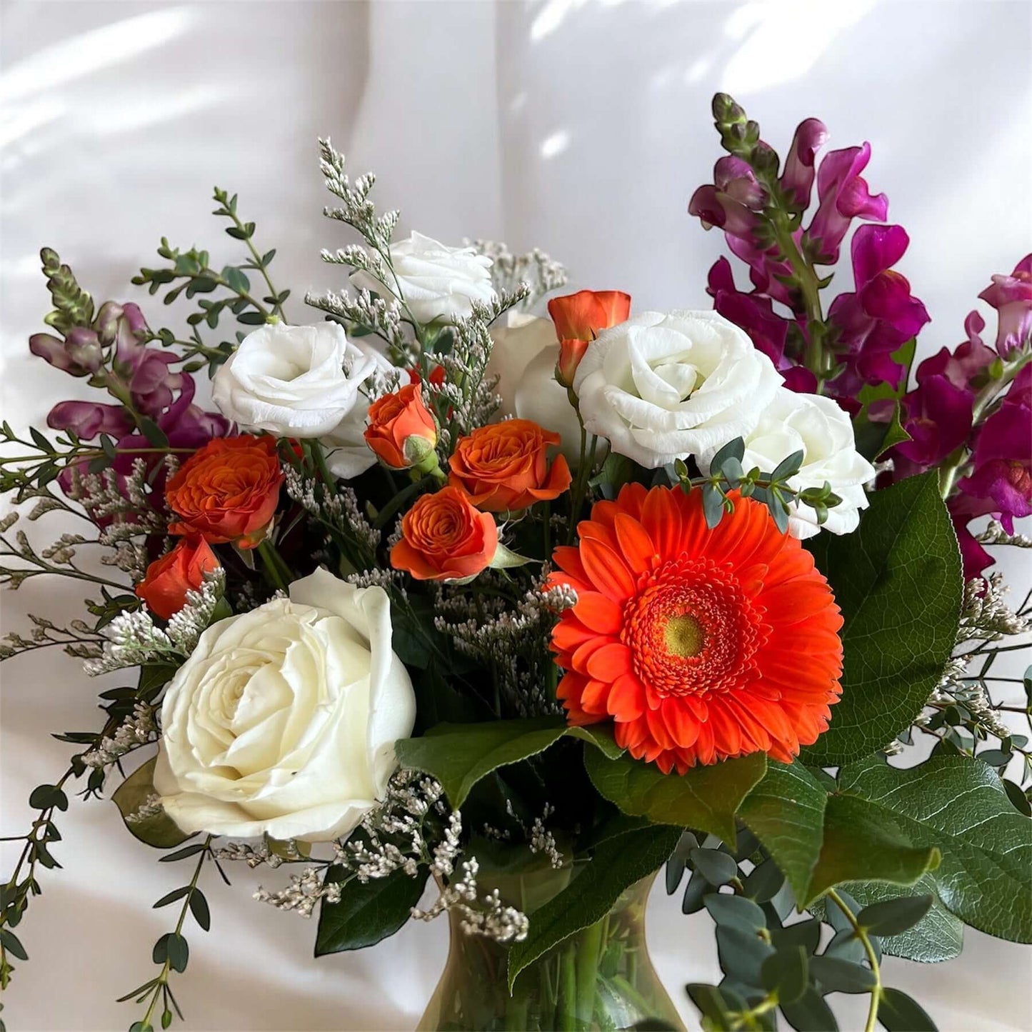 "Luxury floral bouquet with handpicked roses, hydrangeas, and greenery in a glass vase, ideal for weddings, anniversaries, and celebrations